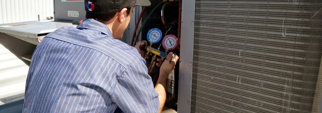 HVAC technician servicing a condenser unit in Sparta