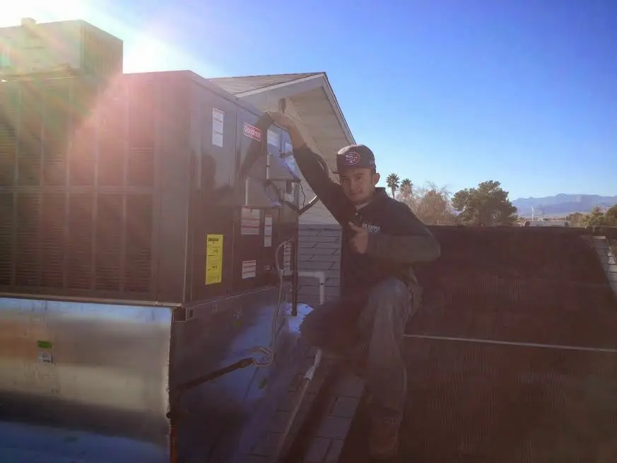 HVAC technician performing HVAC Inspection on a rooftop unit in Sparta